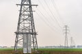 Electricity distribution system. High voltage overhead power line, power pylon, steel lattice tower standing in the field. Royalty Free Stock Photo