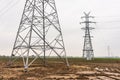 Electricity distribution system. High voltage overhead power line, power pylon, steel lattice tower standing in the field. Blue Royalty Free Stock Photo