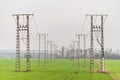 Electricity distribution system. Two-track high voltage overhead power line, power pylon, steel lattice tower standing on field