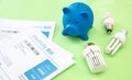 Electricity and gas bills, piggy bank, light bulb and heating thermostat Royalty Free Stock Photo