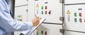 Technician checking air handling unit AHU starter button control panel of heating and air Royalty Free Stock Photo