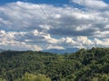 Electricity infrastructure. power lines across mountains landscape, blue sky, green fields and path. Energy industry. Copy space Royalty Free Stock Photo