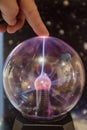 Electricity lighting ray going to a finger hand on a powerful spark sphere