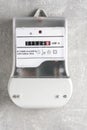 Electricity meter on gray wall. Concept of electricity consumption Royalty Free Stock Photo
