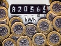 Electricity meter and kWh symbol surrounded with one pound coins. Royalty Free Stock Photo
