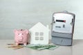 Electricity meter, piggy bank, house model and euro banknotes on white wooden table Royalty Free Stock Photo