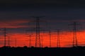 Electricity pole sunset. Dark night with orange clouds electricity poles in nature, Czech Republic. Energy in nature. Sunrise