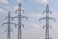 3 electricity poles closeup. Power lines web against morning blue sky with white clouds. Energy supply Royalty Free Stock Photo