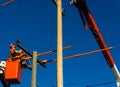 Electricity power lineman in crane doing maintenance and repairs on poles and cables Royalty Free Stock Photo