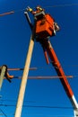 Electricity power lineman in crane doing maintenance and repairs on poles and cables Royalty Free Stock Photo