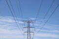Electricity pylon against blue wispy cloudy sky with space for copy