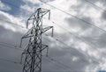 An electricity pylon against a cloudy sky. Insultaors lit by sunlight. Royalty Free Stock Photo