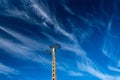 Electricity pylon against dark blue sky with white clouds Royalty Free Stock Photo