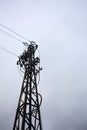 Electricity pylon with over head cables passing on it and a cloudy sky as background Royalty Free Stock Photo