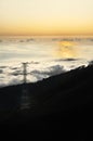 Electricity pylon over valley at sunset