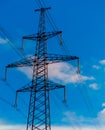 Electricity pylon silhouette against blue sky background. High voltage tower. Royalty Free Stock Photo