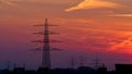 Electricity Pylon silhouette over dramatic orange sunset sky Royalty Free Stock Photo