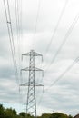 Electricity pylons against a blue and white sky. Large grey pylon with earth wire and electrical conductors. Royalty Free Stock Photo