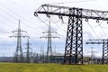 Electricity pylons conducting current from distribution power station with dramatic cloudy sky copy space Royalty Free Stock Photo