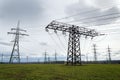 Electricity pylons conducting current from distribution power station with dramatic cloudy sky copy space Royalty Free Stock Photo