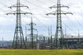 Electricity pylons conducting current from distribution power station with dramatic cloudy sky copy space Royalty Free Stock Photo