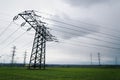 Electricity pylons conducting current from distribution power station with dramatic cloudy sky copy space Royalty Free Stock Photo