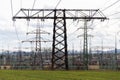 Electricity pylons conducting current from distribution power station with dramatic cloudy sky copy space Royalty Free Stock Photo