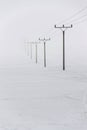 Electricity pylons from distribution power station in foggy winter freeze Royalty Free Stock Photo