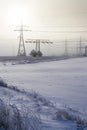 Electricity pylons from distribution power station in foggy winter freeze Royalty Free Stock Photo