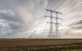 Electricity pylons in a row contrasting against a cloudy sky Royalty Free Stock Photo