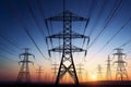 Electricity pylons and power lines in the rural countryside at sunset