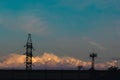 Electricity pylons, power lines silhouetted against a cloudy sky at sunset. Royalty Free Stock Photo