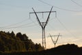 Electricity pylons, power lines and trees silhouetted against a Royalty Free Stock Photo