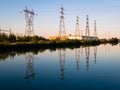 Electricity pylons reflecting in still water