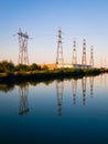 Electricity pylons reflecting in still water