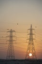 Electricity Pylons Silhouetted At Sunset Royalty Free Stock Photo