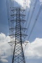 Electricity transmission lines and pylon silhouetted against blue sky and cloud,high voltage tower Royalty Free Stock Photo