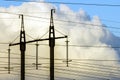 Electricity transmission power lines against white clouds. High Royalty Free Stock Photo