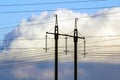 Electricity transmission power lines against white clouds. High Royalty Free Stock Photo