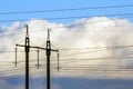 Electricity transmission power lines against white clouds. High Royalty Free Stock Photo