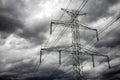 Electricity transmission power lines and dark clouds on sky Royalty Free Stock Photo