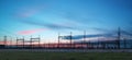 Electricity transmission pylon silhouetted against blue sky at d