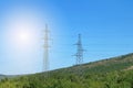 Electricity transmission pylons against blue sky. Transmission line of electricity to rural in mountains Royalty Free Stock Photo