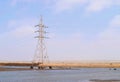 Electricity Transmission Tower with Overhead High-Voltage Power Line Surrounded by Water in Flood -