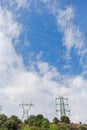 Electricity transmission towers against blue sky background Royalty Free Stock Photo