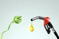 Electricity versus combustible fuel. Gas station nozzle and electrical plug. Technology, car costs, electric car vs gasoline car. Royalty Free Stock Photo