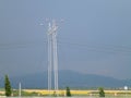 Electrification poles on the background of a wheat field and a distant mountain Royalty Free Stock Photo