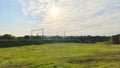 Electrified railroad tracks are laid along the mound among grassy meadows and mixed forests. A metal bridge on a concrete base was