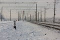 Electrified railway tracks with red railway signals - railway station with traffic sign in winter Royalty Free Stock Photo