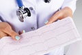 Electrocardiogram, ecg in hand of a female doctor. Medical health care. Clinic cardiology heart rhythm and pulse test closeup.